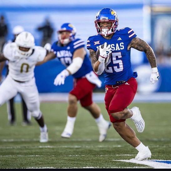 Kansas athlete number 25 running with the football