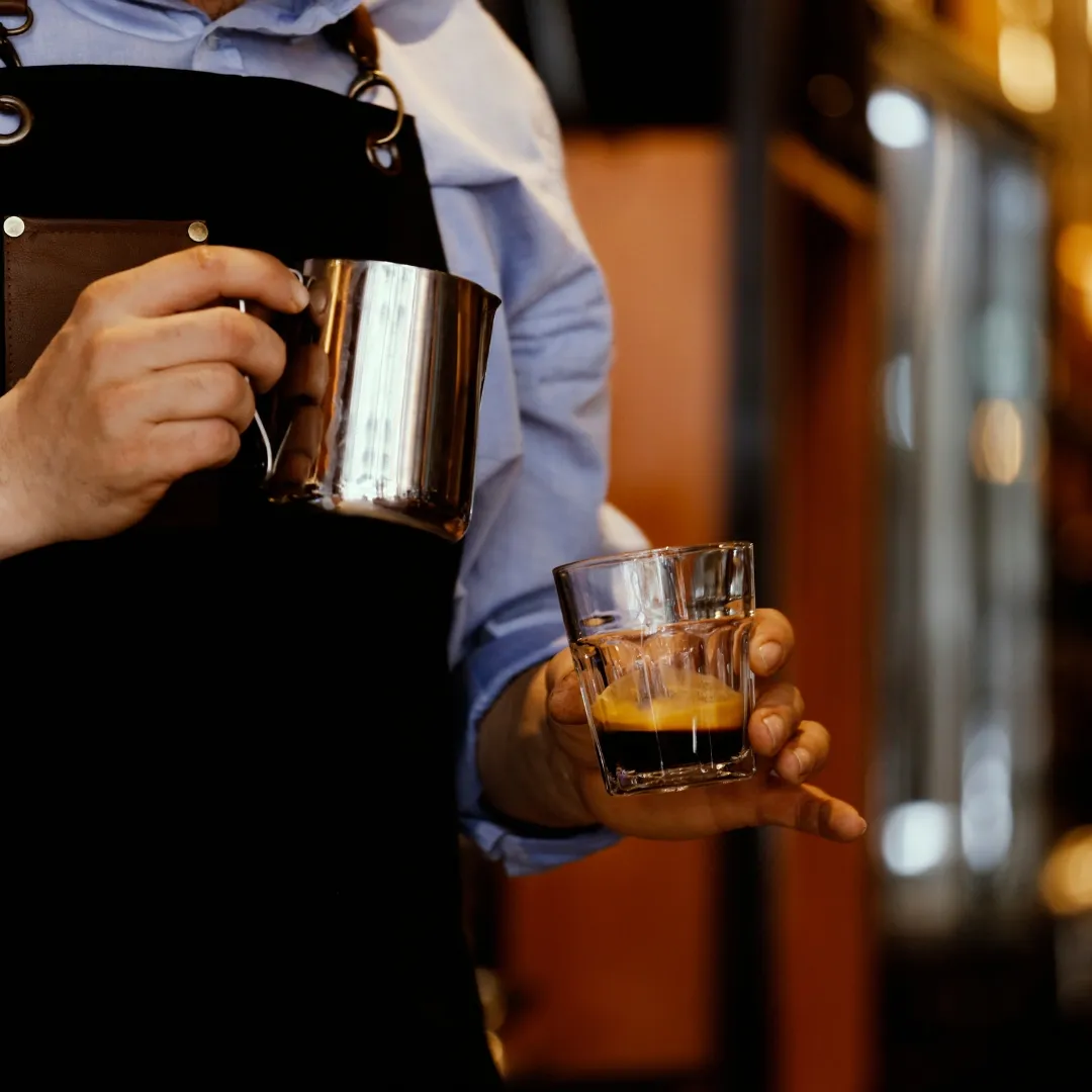 a barista making a long coffee for a cappuccino
