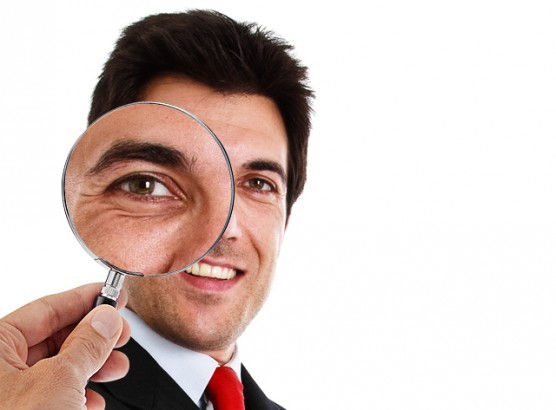 Homem executivo olhando através de uma lupa