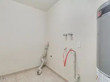 Before laundry room remodel featuring modern fixtures, new flooring, and contemporary finishes by Rattler Contracting.