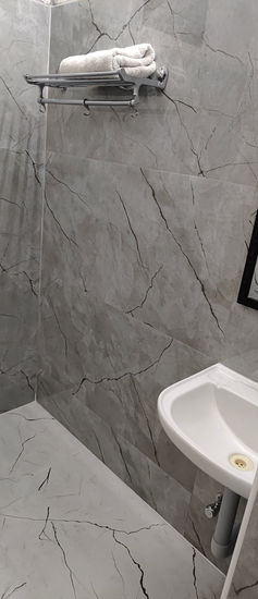 Bathroom interior with sink and mirror. Marble walls with amenities. Zingle Stay Airport.