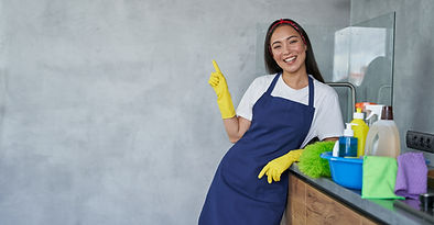 cheerful-young-woman-cleaning-lady-in-protective-gloves-smiling-at-camera-pointing-up-whil