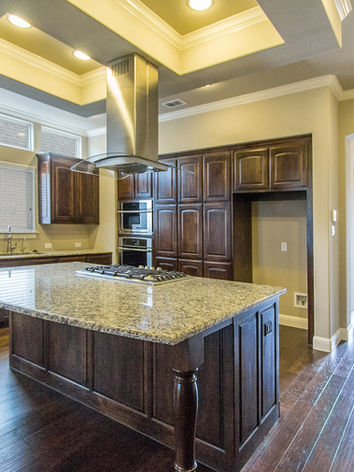 Real estate photo of an entryway and kitchen with island.