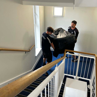 Phil and Leon from Afordable Services moving furniture into someones new home.