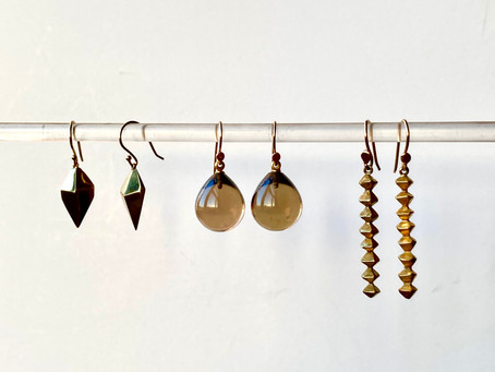 A trio of earrings in silver, smoky quartz, brass and gold