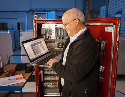 Techniker bei der Inbetriebnahme mit Laptop in der Hand