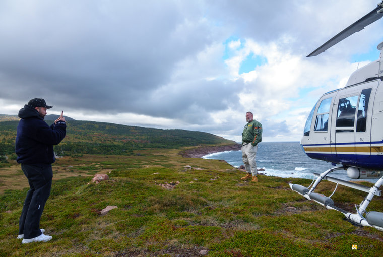 Guests beside a helicopter on Cape Breton’s open coastal terrain