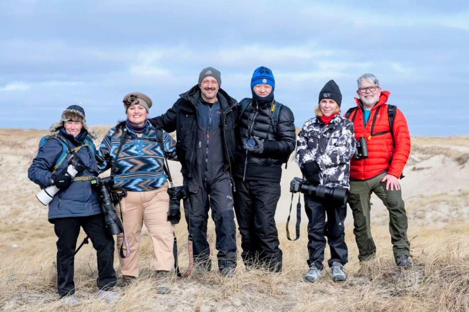 Six expedition participants with cameras among the dunes on Sable Island