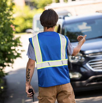 Image of a volunteer working on traffic control while wearing the MAX434 volunteer vest in Blue
