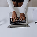 online-training showing a person hands typing on a laptop while they train for Food Safety, quality, and compliance. 