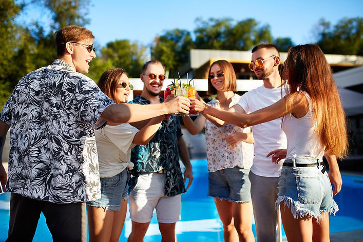 Group of friends toasting by a private villa pool during a group retreat in Costa Rica