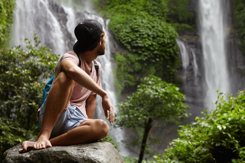 Traveler resting by a jungle waterfall during a private group retreat in Costa Rica
