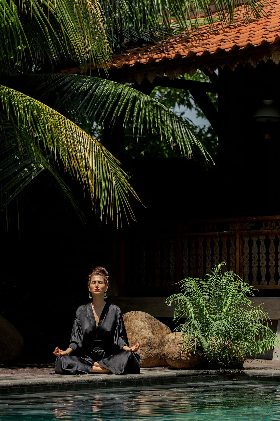 Woman meditating under palm trees at dusk during a wellness retreat in Costa Rica