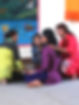 Four Nepali women practicing emotional first aid, sitting close together with arms around each other and holding hands