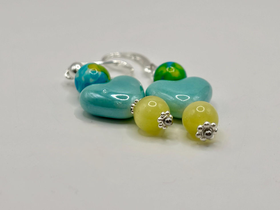 Thumbnail: Blue heart and yellow cat's eye earrings on white surface