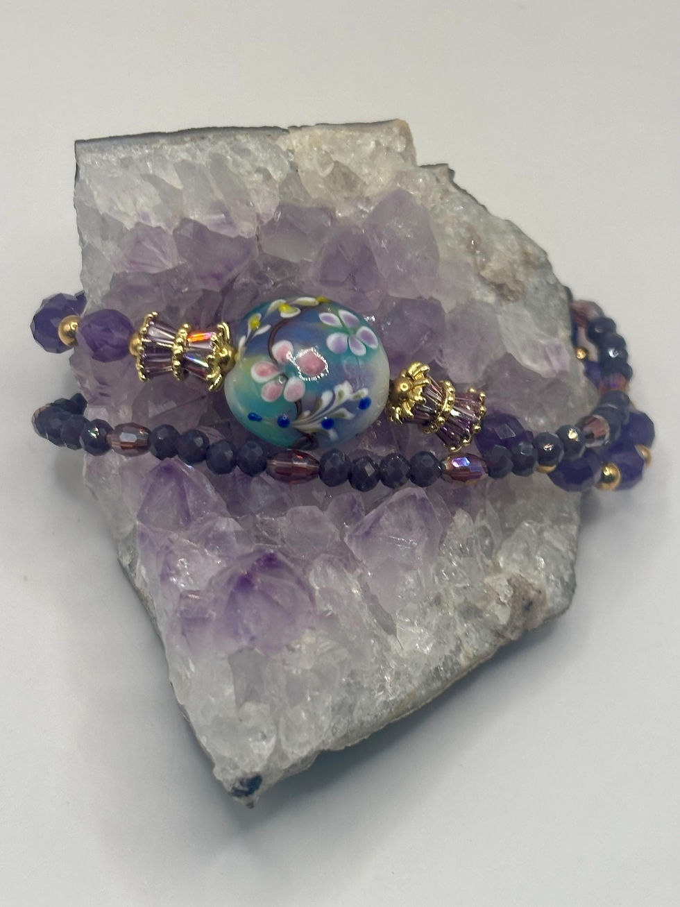 Thumbnail: Amethyst double strand artisan bracelet on crystal cluster