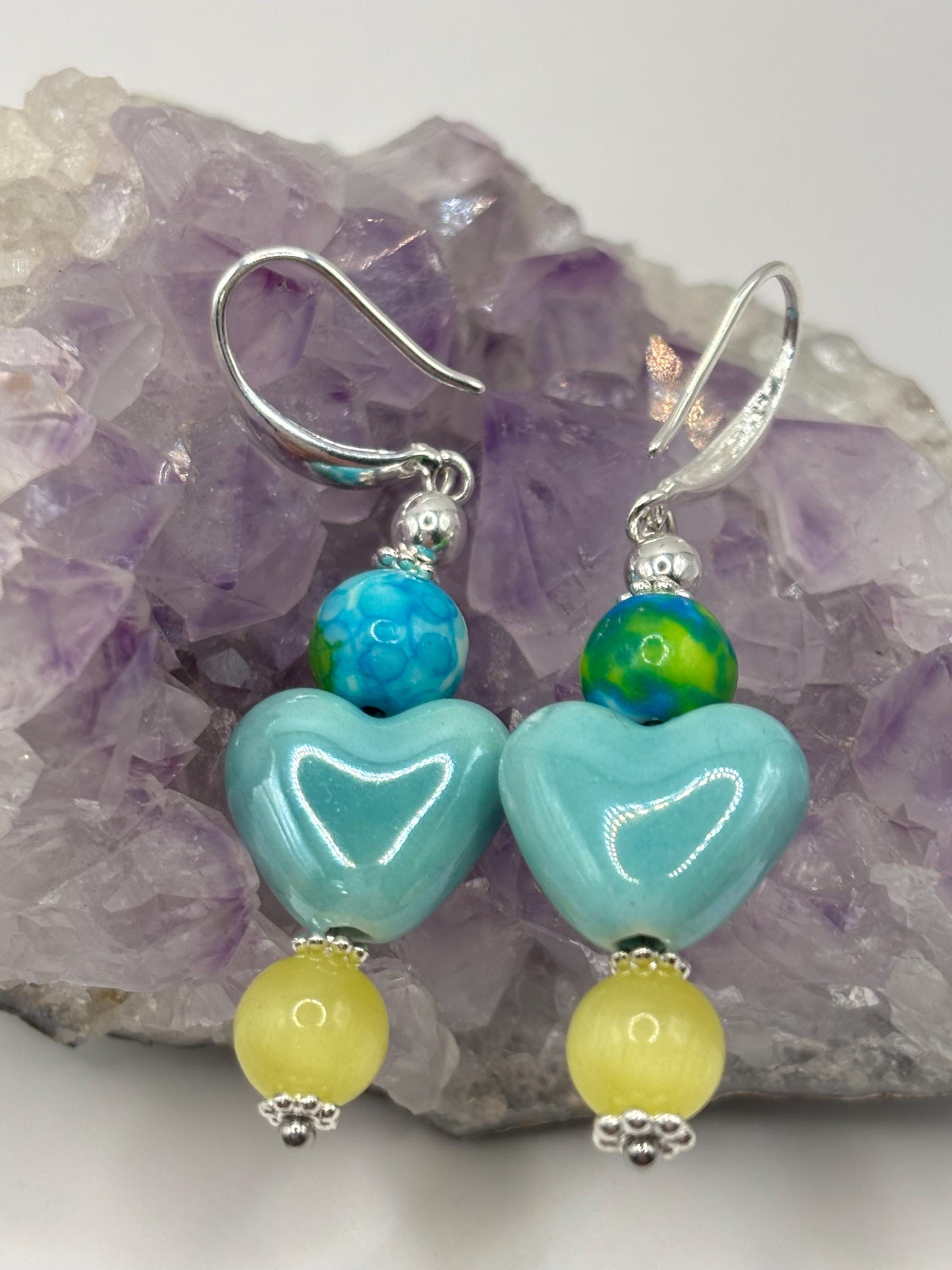 Blue heart and cat's eye earrings on an amethyst cluster