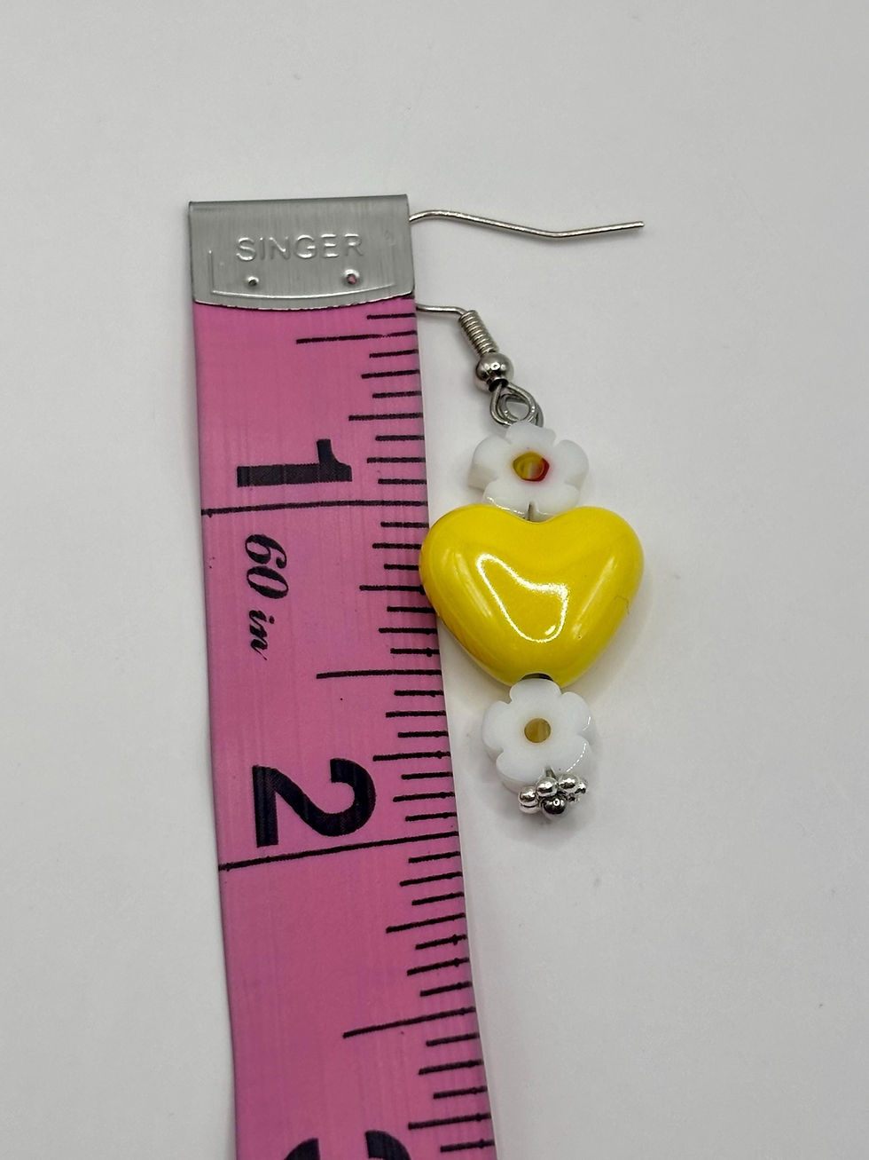 Thumbnail: Yellow heart cottagecore earring measured at two inches.