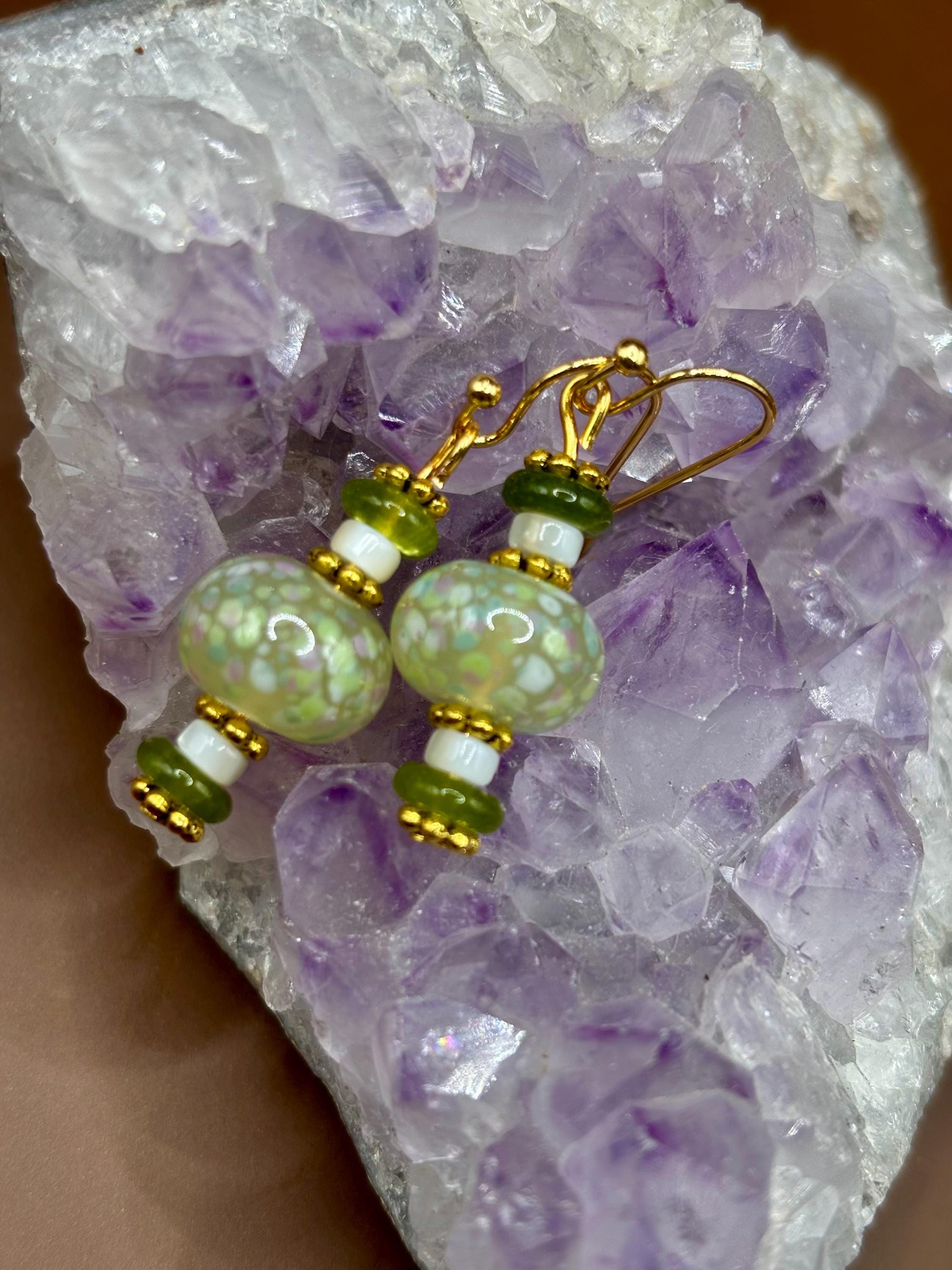 Green lampwork dangle earrings on gold wires atop amethyst.