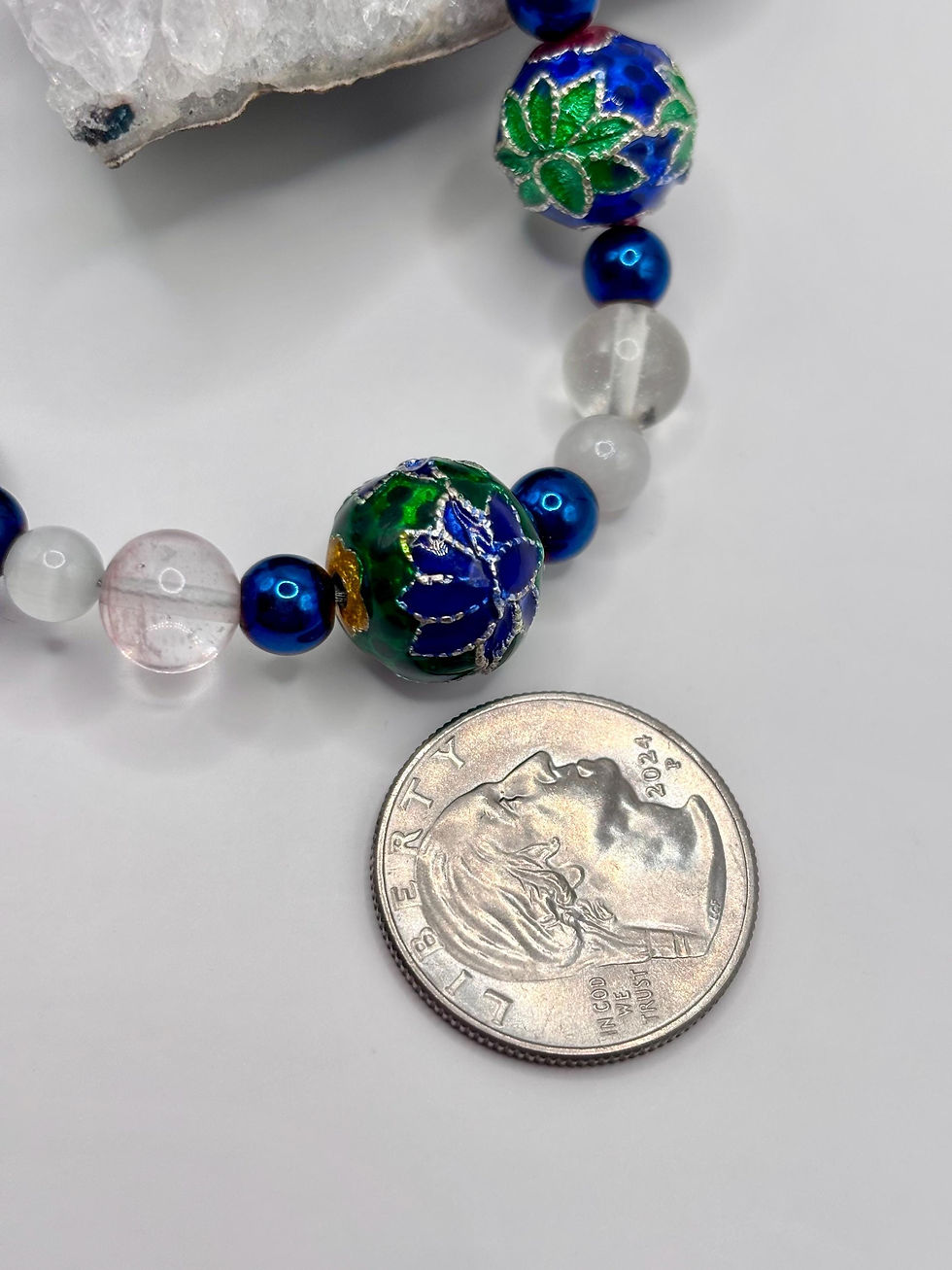 Thumbnail: Floral cloisonné bracelet with blue enamel beads next to a coin for scale