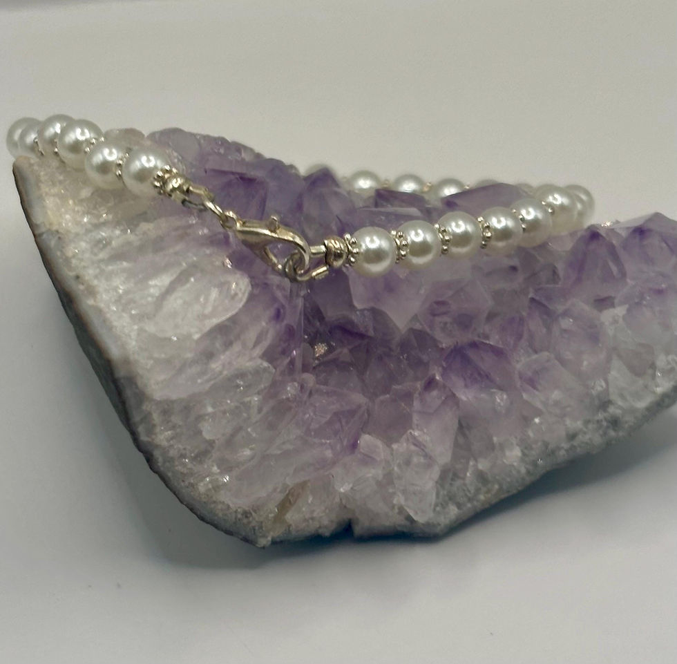 Beaded pearl necklace draped on a purple crystal.