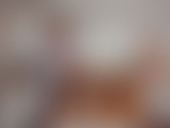 A man and a woman smiling while packing kitchen items in cardboard boxes on a wooden countertop. sell your home for cash buffalo