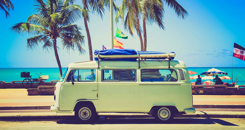 Retro camper van with surfboards on a tropical beach with palm trees - Keeba Media