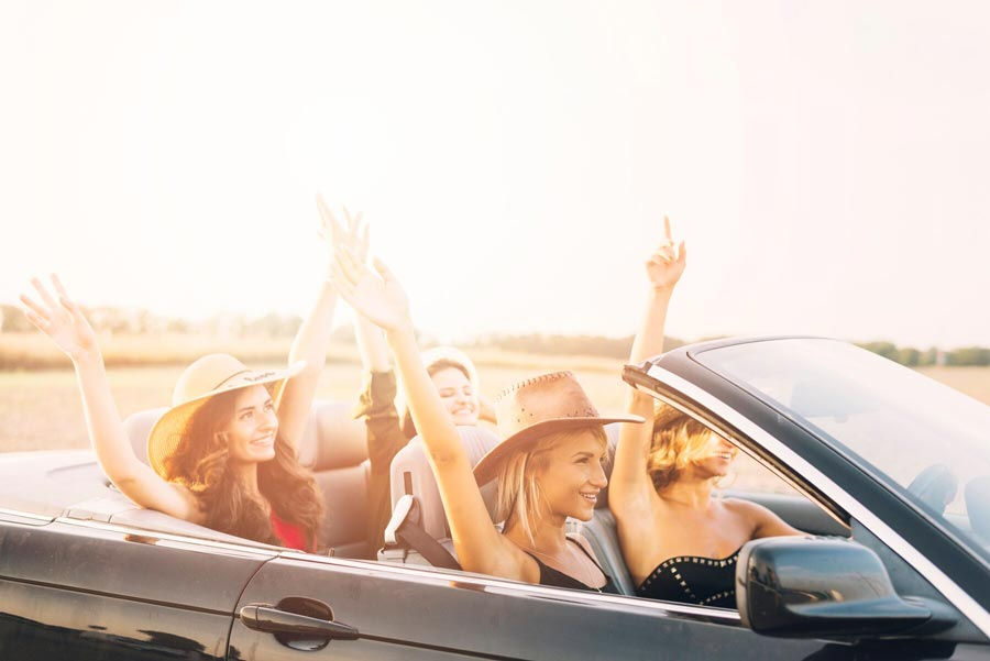 women-riding-car-with-hands-up_23-2147932190.jpg