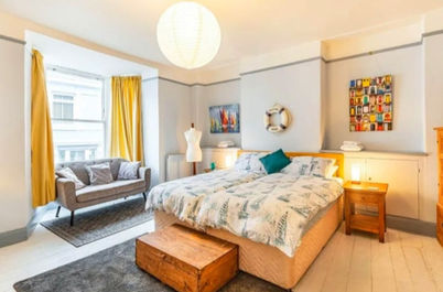 Spacious Family Room with Twin Beds & a Cot, a Sitting Area, and Adjacent Bathroom.