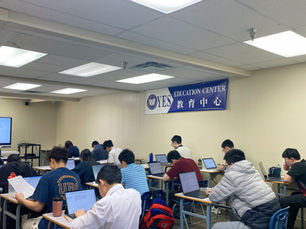 在YES教育中心的教室内,多名学生使用笔记本电脑进行考试