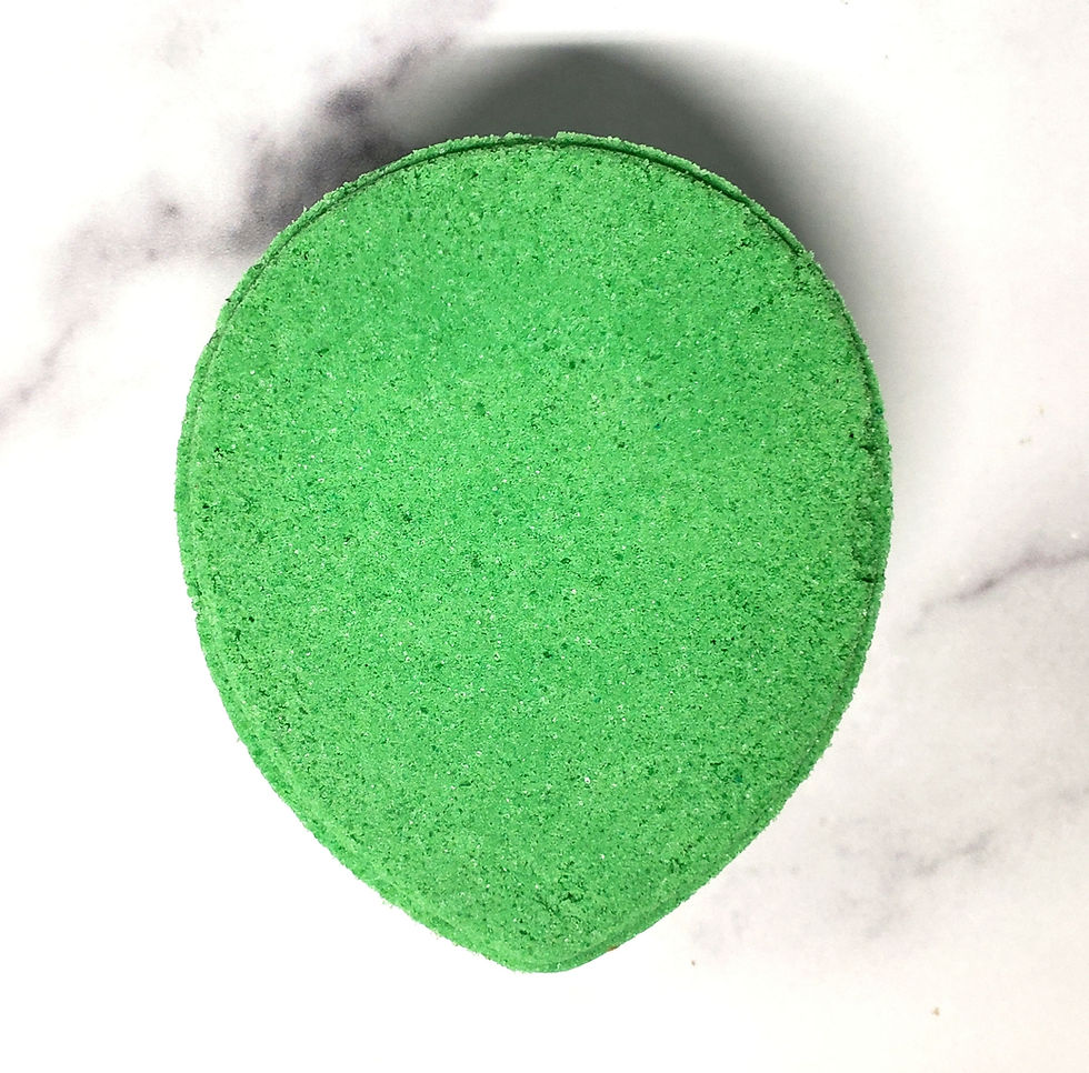 Green alien head-shaped bath bomb with large black eyes, displayed without background distractions on a clean surface