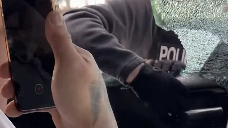 ICE agent smashing a car window. Photo courtesy of ProPublica.