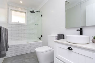 renovated bathroom in modern white subway tile with black tapeware