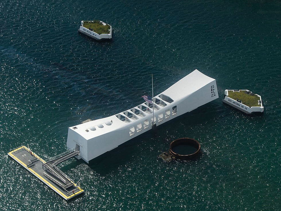 White USS Arizona Memorial on blue water with small green-topped structures. Flag at half-mast. Somber, reflective mood.