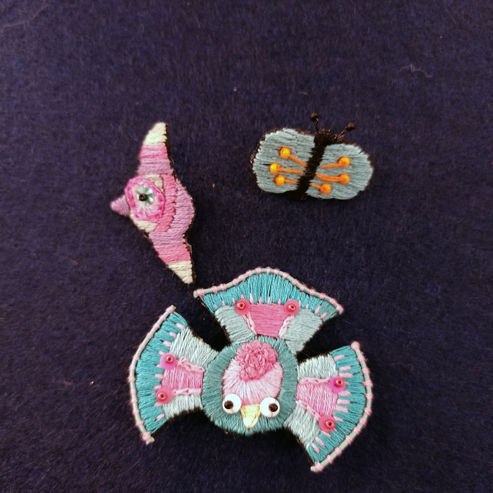 Thumbnail: broche brodée avec perles et sequins en forme de paon bleu et rose