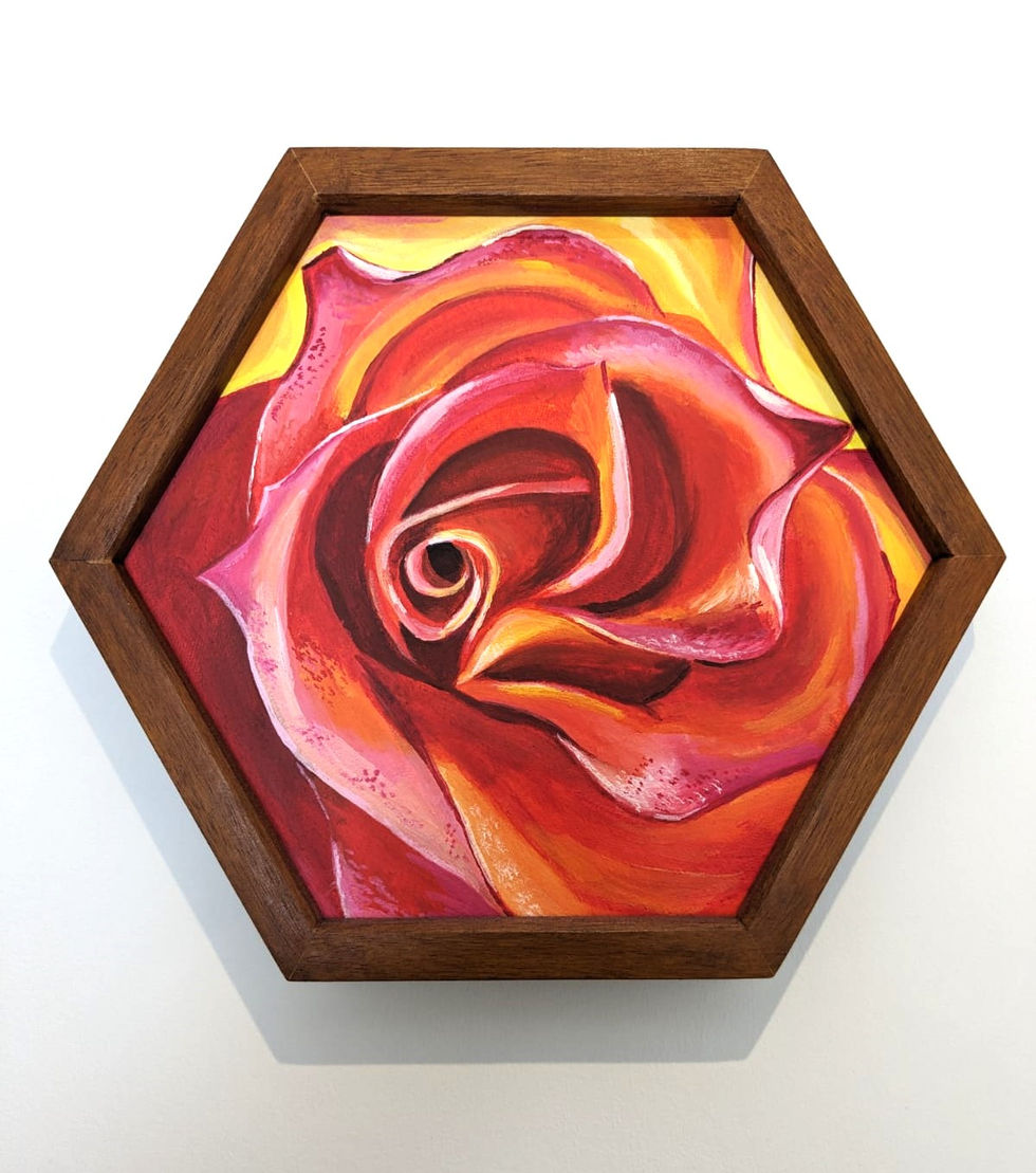 an acrylic painting of a red magnified rose on a hexagon canvas, framed.