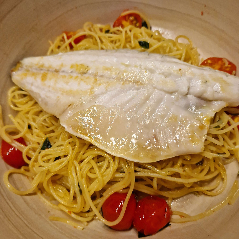 Wolfsbarschfilet auf Knoblauchspaghetti mit Tomaten