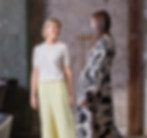 Två kvinnor pratar, klädda i moderiktiga kläder