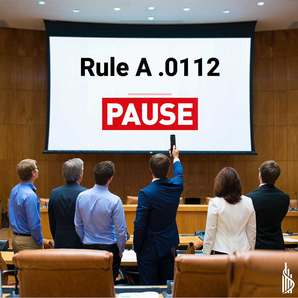 Seven people in suits face a large screen displaying "Rule A .0112" and "PAUSE" in red. One raises a remote in a wood-paneled room.