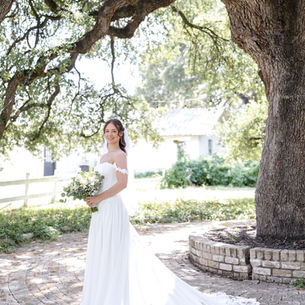 Bride standing under tree