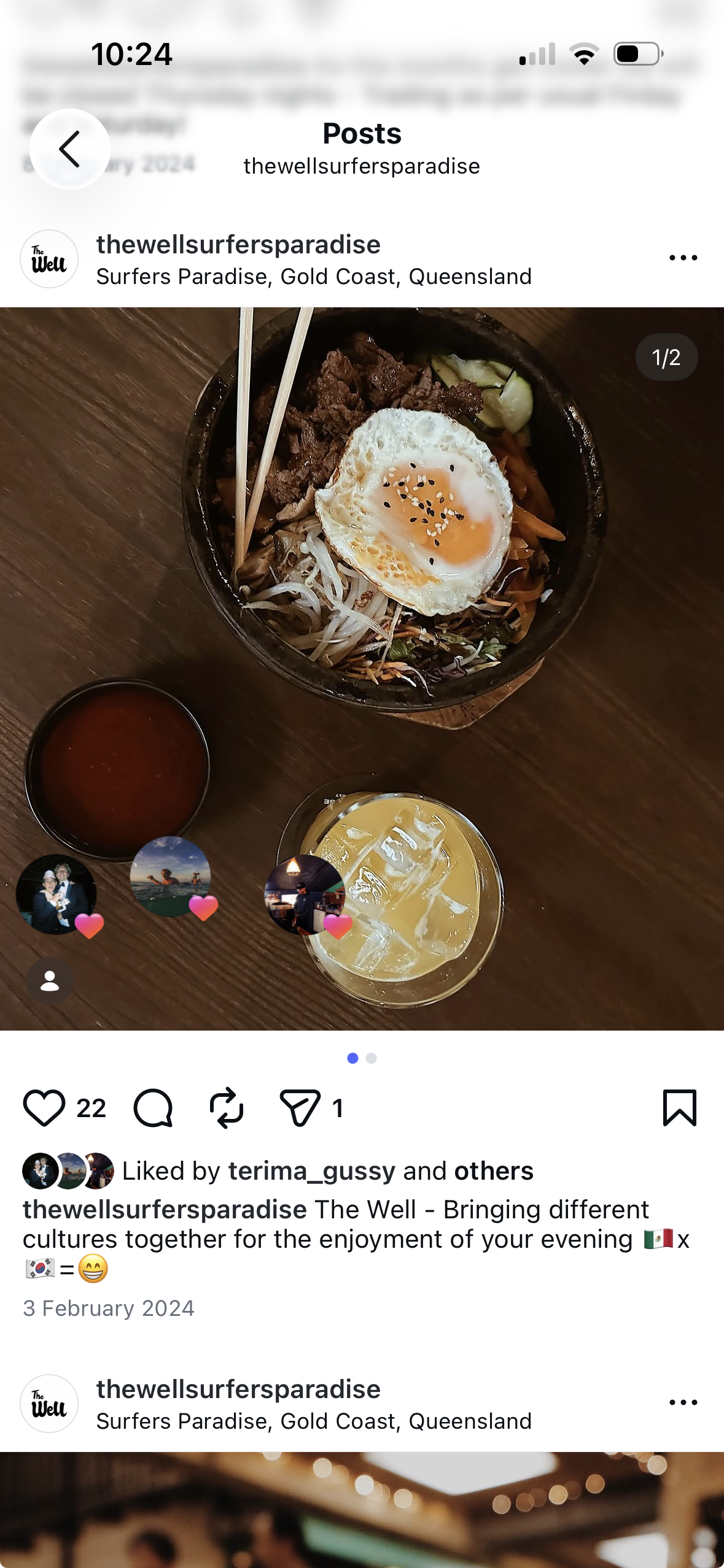 Rice bowl topped with a fried egg, meat and vegetables on a table at The Well