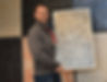 Bild von Firmenchef Joachim Schrumpf vor eine Musterwand, hält ein Farbmuster in der Hand