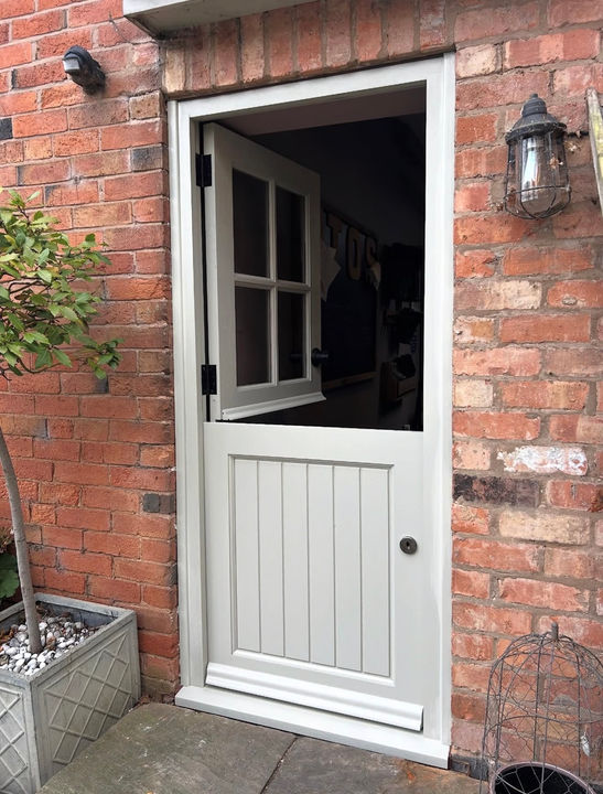 Bespoke stable door shown open, with glazed upper section and boarded lower panel.