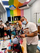 Pupusería Las Cabañas team interacting with children during a community activity at the foundation