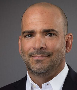 Blonde woman smiling wearing a blue jacket and a white shirt
