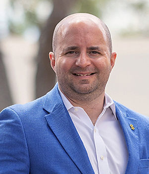 Blonde woman smiling wearing a blue jacket and a white shirt
