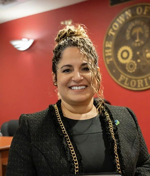Blonde woman smiling wearing a blue jacket and a white shirt