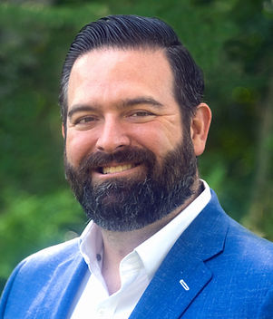 Blonde woman smiling wearing a blue jacket and a white shirt