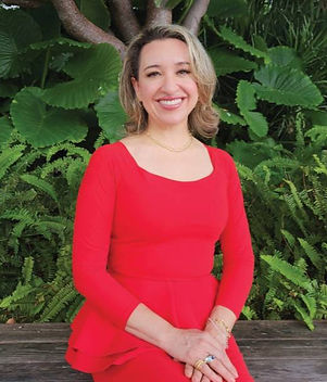 Blonde woman smiling wearing a blue jacket and a white shirt