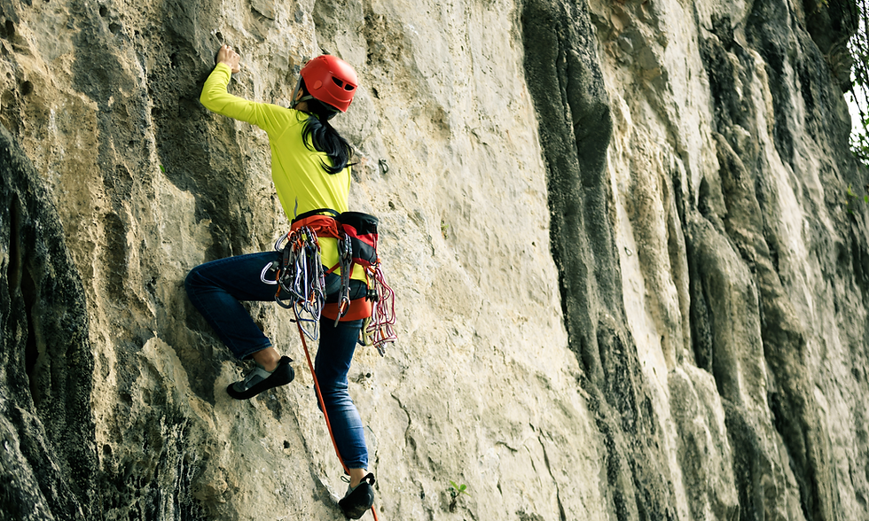 Female rock climber scaling a steep cliff outdoors, illustrating strength, endurance, and fitness.